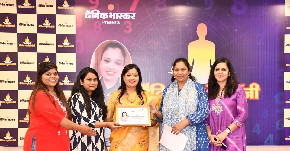 Dr. Abha Jain receiving a framed certificate of honour from the Dainik Bhaskar team